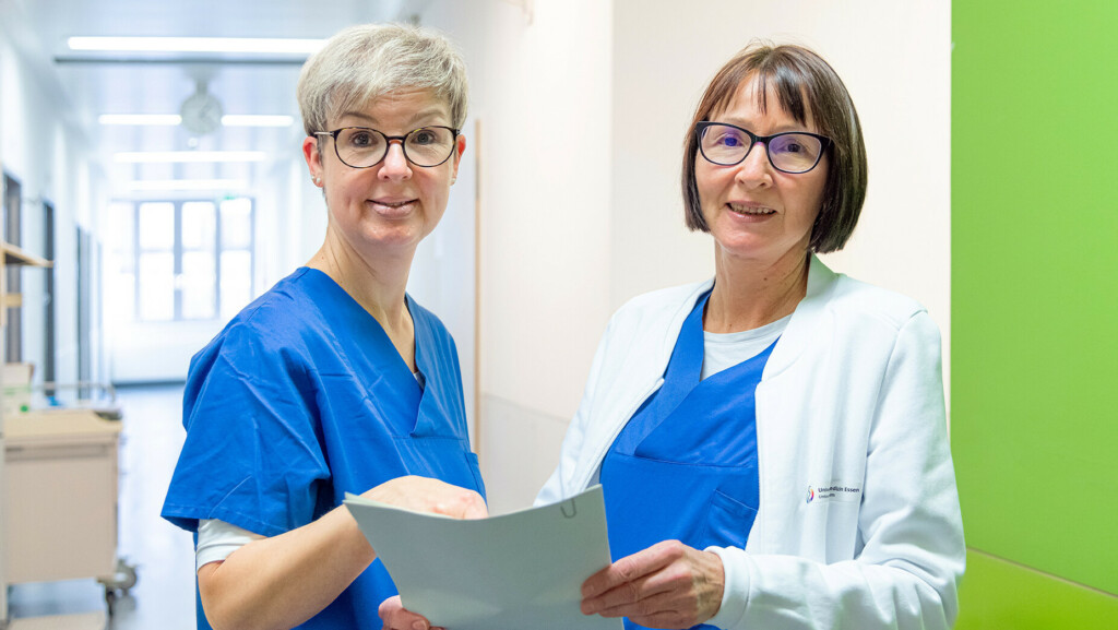 Mitarbeitende auf einem Klinikflur mit Unterlagen in der Hand