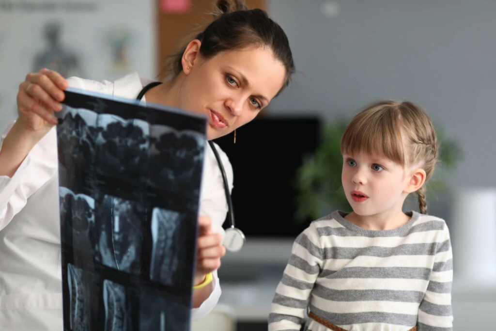 Ärztin zeigt einem Kind eine Röntgenaufnahme